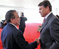 Farouk Swami, left, shakes hands with Texas Gov. Rick Perry during the announcement of Farouk Systems' expansion in Houston.
