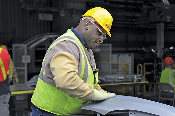 A Toyota team member inspects Corolla parts at the new plant in Blue Springs, Miss.