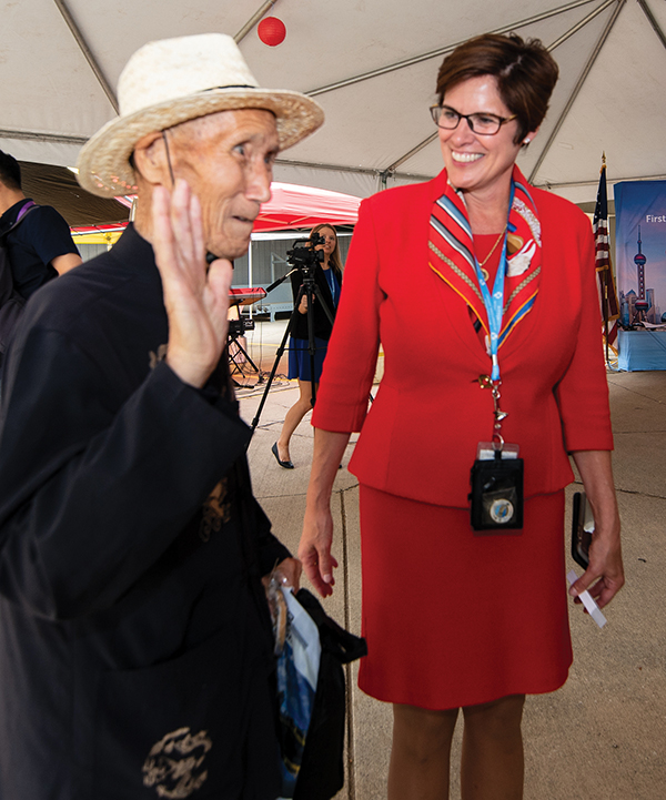 Airport CEO Christina Cassotis greets passengers from an inaugural Shanghai charter flight.